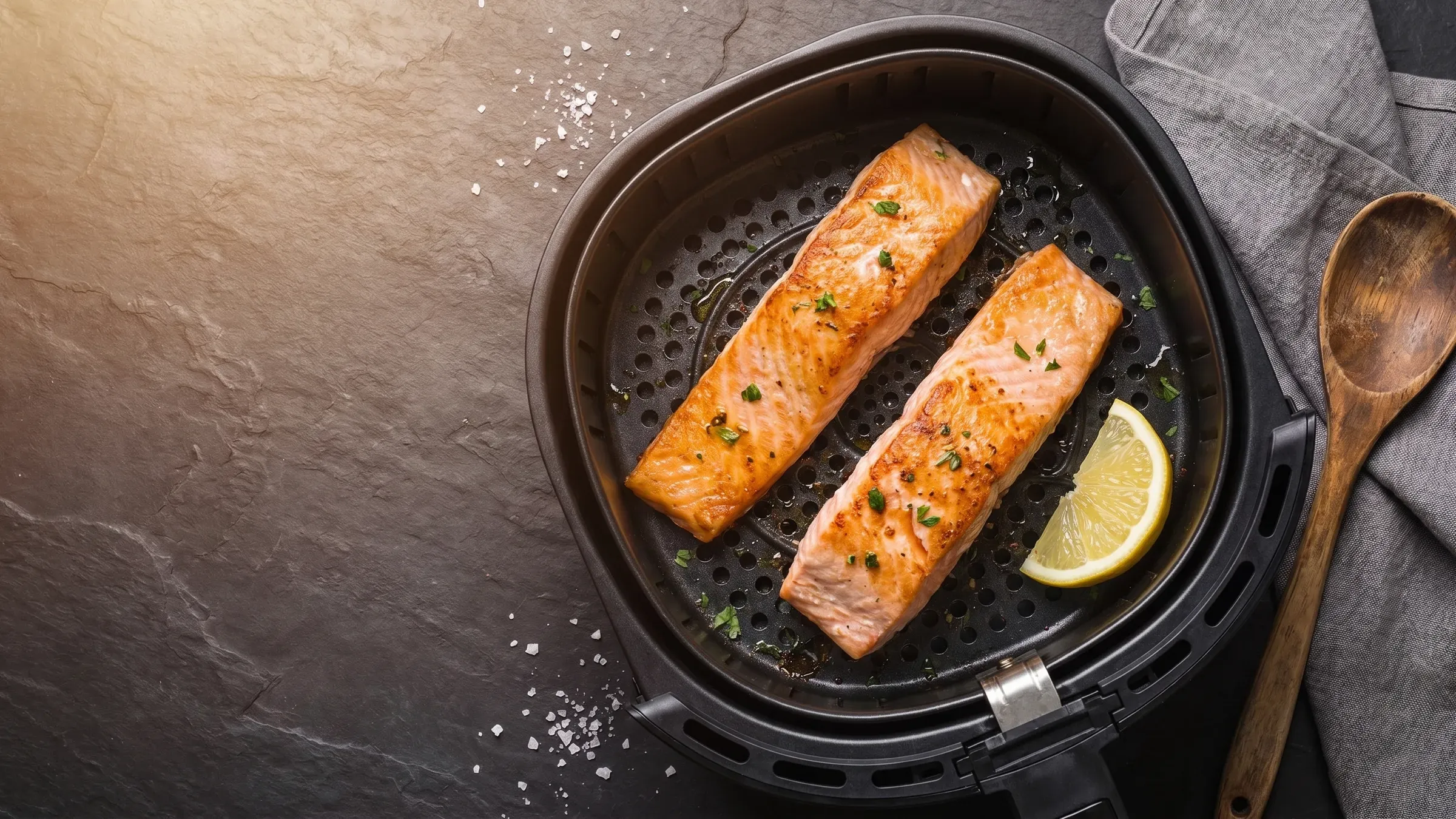 Illustrative photo of a salmon fillet in a black air fryer basket